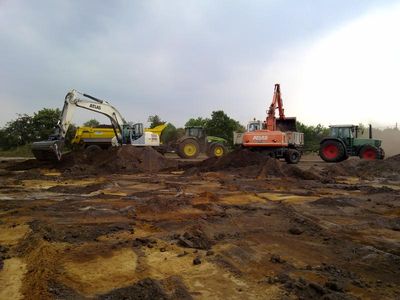 Bagger und Schlepper bei Erdarbeiten auf einer großen Fläche