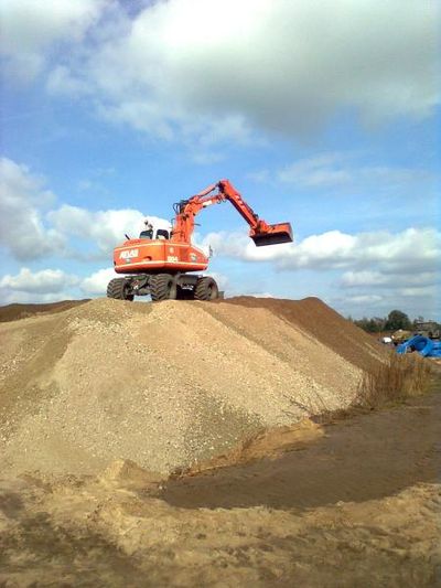 Mobilbagger auf einem Sandhaufen