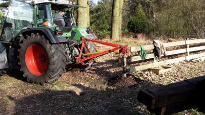 Erdbohrer am Fendt-Schlepper bohrt ein Loch für einen Zaunpfosten