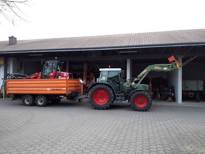 Fendt-Schlepper mit Stoll-Frontlader und Kipper vor der Maschinenhalle