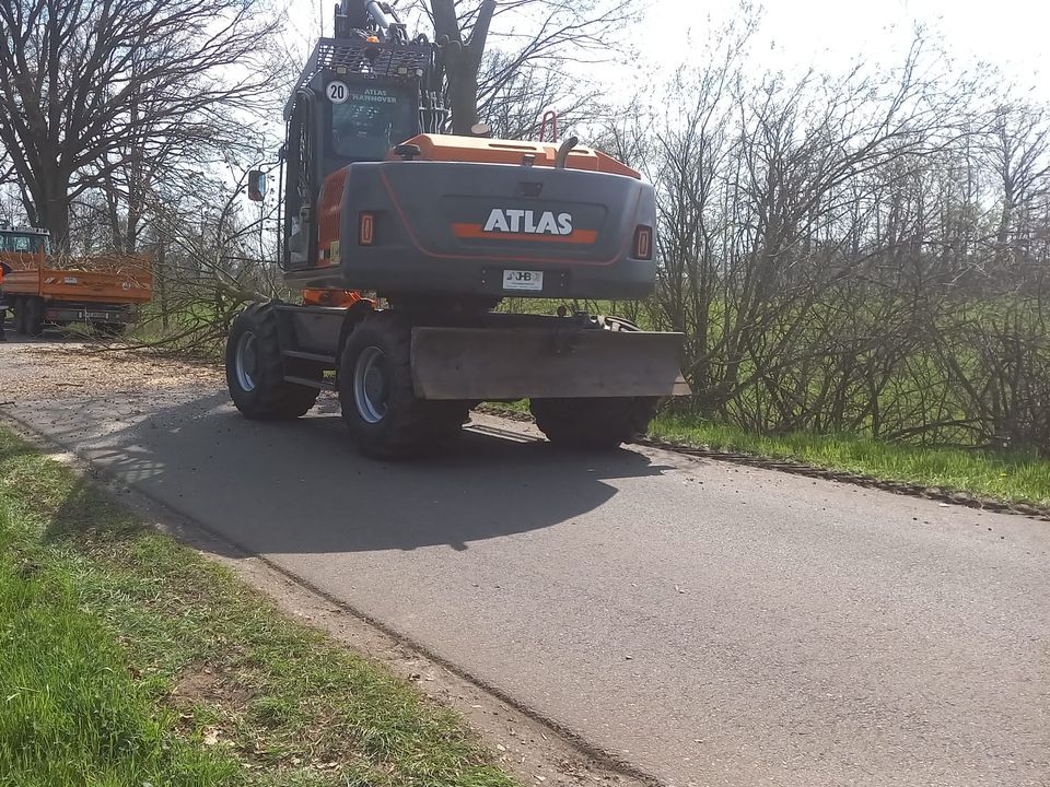 Mobilbagger Atlas 140W von hinten auf einer Landstraße