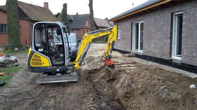 Minibagger von Wacker Neuson beim Aushub an einem neu gebauten Haus