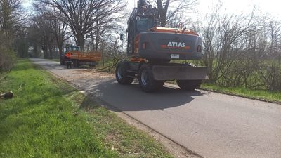 Mobilbagger Atlas 140W auf einer Landstraße bei Fällarbeiten am Straßenrand